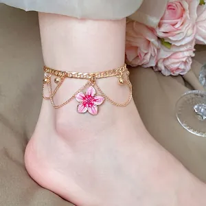 Elegant gold-toned anklet featuring a pink enamel flower pendant for stylish beach vacations