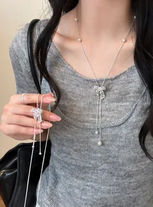Detailed view of elegant zircon hollow bow necklace with pearls on a silver chain