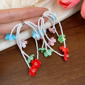 Handmade beaded tassel earrings with colorful resin flower charms in detail view