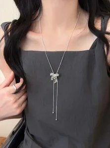 Elegant hollow-out bow pendant necklace with zircons on a model's neck.