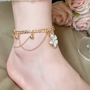 Elegant gold anklet with white enamel flower charm and golden beads for summer beach jewelry.