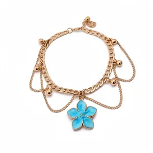 Gold chain anklet featuring a light blue enamel flower pendant and ball charms.