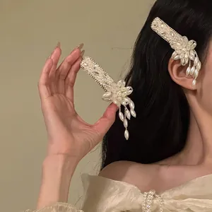 Close-up of elegant French pearl hair clip with flower design and hanging tassels