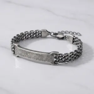 Detailansicht eines silbernen Mesh-Kettenarmbands mit gebogener, gravierbarer Platte.
