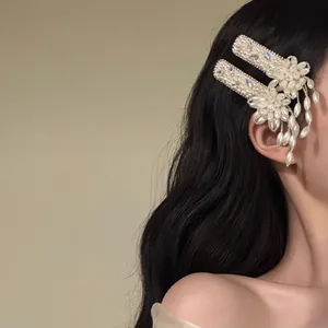 Detailed side view of elegant French style pearl and flower tassel hair clips