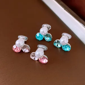 Dettaglio degli orecchini a clip con perle e strass colorati per orecchi senza buco.