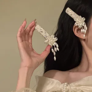 Detail view of an elegant pearl flower tassel hair clip with rhinestones on a model.