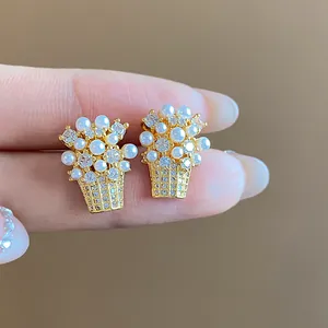 Primo piano di eleganti orecchini a lobo a cesto di fiori con perle e zirconi lucenti
