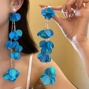 Primo piano di orecchini a nappa con paillettes blu e design circolare a strati.