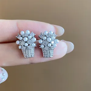Vista dettagliata di orecchini a cesto di fiori in argento con perle e zirconi
