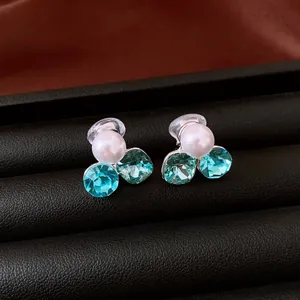 Primo piano di orecchini a clip con perle e cristalli blu per orecchie senza buchi