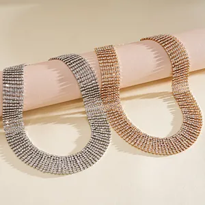 Detailed view of sparkling gold and silver rhinestone fringe choker necklaces on props.