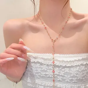 Elegant sweet cherry pink flower Y-shaped necklace worn by model with white lace top