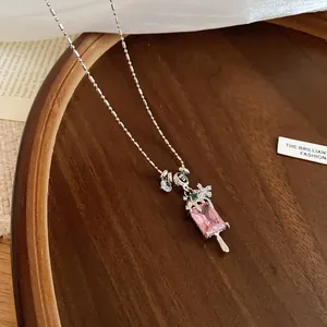 Vue détaillée d'un pendentif en forme d'esquimau rose avec zircons et détails floraux