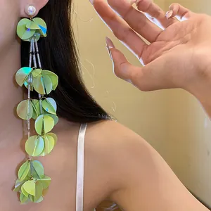 Eleganti orecchini pendenti con nappine in conchiglia verde chiaro in stile retrò su modella