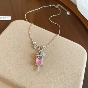 Gros plan du collier avec pendentif glace en zircon rose, fleurs et accents de pierre verte.