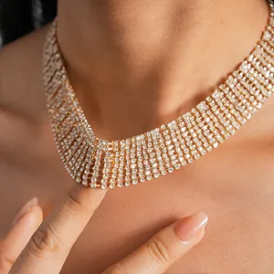 Close-up of elegant luxury gold rhinestone tassel collar necklace on a model's neck