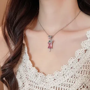 Gros plan d'un collier avec pendentif glace en zircon rose et accent floral au cou