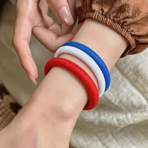 Gros plan détaillé de bracelets à ressort rouges, blancs et bleus portés au poignet