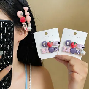 Detail of strawberry and polka-dot bow hair clips with pearls and rhinestones