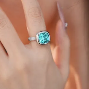 Primo piano di un elegante anello in zircone verde quadrato con una fascia in pavé