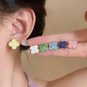 Macro view of colorful camellia flower stud earrings shown in multiple vibrant pastel shades