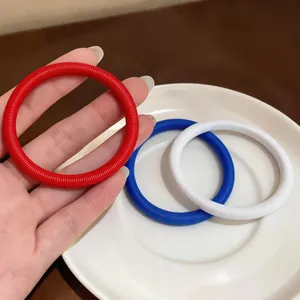 Vue macro de bracelets minimalistes à chaîne à ressort en rouge, bleu et blanc