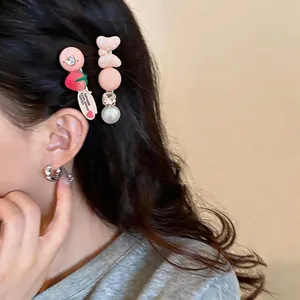 Close-up detail of strawberry and bow hair clips with pearls and rhinestones in hair