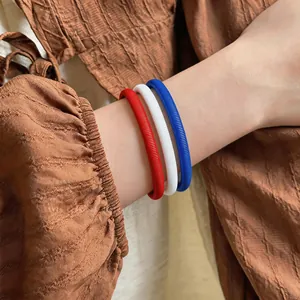 Vue détaillée d'un ensemble de bracelets à ressort rouges blancs et bleus sur poignet