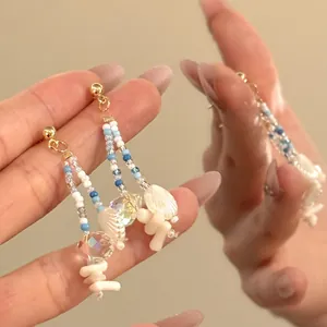 Detailed close-up of Bohemian beaded earrings with white shells and crystal pendants