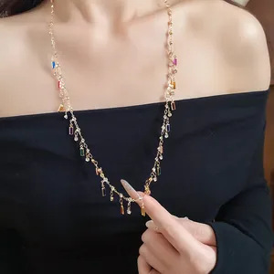 Detailed view of a gold necklace featuring colorful square acrylic pendants and rhinestones