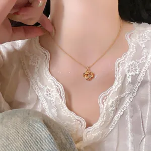 Gros plan d'un élégant collier pendentif nœud doré sur fond de dentelle