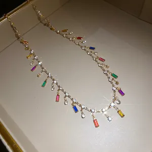 Close-up detail of colorful acrylic square pendants on a sparkling gold rhinestone necklace