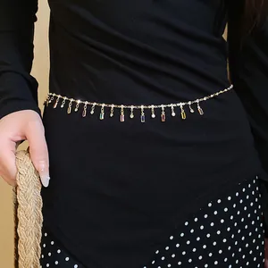 Close-up of a gold chain belt featuring colorful rectangular pendants and rhinestones