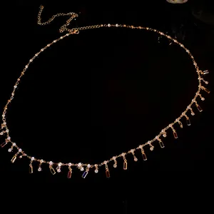 Detail showing colorful rectangular pendants on a rhinestone-studded gold chain necklace
