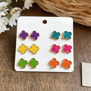 Close-up of vibrant colorful dopamine style flower stud earrings set on a white card