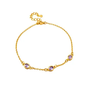 Elegantes goldenes Armband mit drei ovalen violetten Edelsteinen auf weißem Hintergrund.