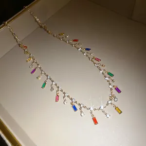 Detailed view of gold chain necklace with colorful acrylic charms and sparkling rhinestones