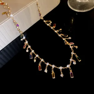 Detail view of elegant gold chain necklace with dangling multicolor rectangular acrylic pendants