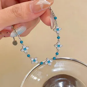Primo piano di un bracciale regolabile in argento con fiori di zirconia e perle turchesi