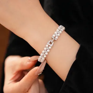 Elegant double-layer pearl bracelet with zircon-studded clasp shown on a model wrist