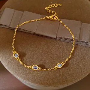 Detailansicht eines eleganten Goldkettenarmbands mit drei violetten Edelsteinen.