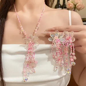 Primo piano di collana e orecchini con perline rosa e nappine floreali iridescenti per donna.