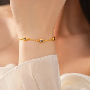 Elegantes minimalistisches Goldkettenarmband mit ovalen lila Steinen an einem Handgelenk.