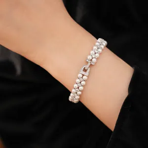 Detail view of a double-strand pearl bracelet with zircon clasp on wrist