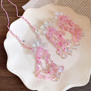 Primo piano di un set di gioielli con nappine di fiori e perline rosa su un piatto