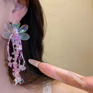 Dettaglio di un orecchino floreale con perline iridescenti e pietre di quarzo rosa