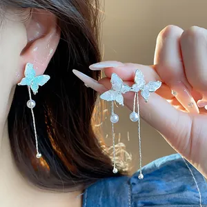 Close-up view of glass butterfly tassel earrings featuring elegant pearl drop accents