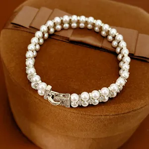 Close-up detail of double-layer pearl bracelet with cubic zirconia paved clasp mechanism.