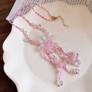 Primo piano di una collana di fiori con perline rosa fatta a mano con eleganti nappine